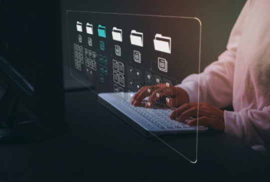 User types on a keyboard while interacting with on-screen file and folder icons, representing organizing and managing digital documents.