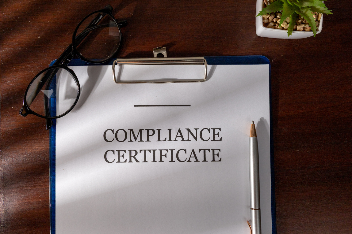 Compliance certificate document on a clipboard, indicating verification of regulatory requirements and readiness for review or approval.