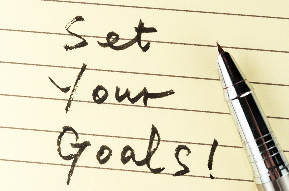 Handwritten note reading ‘Set your goals!’ on lined paper, encouraging users to define and document clear goals.